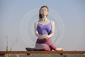 Yoga exercise - woman doing yoga pose meditation in the public park sport healthy concept