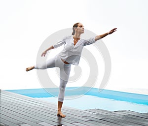 Yoga is freeing. a gorgeous young woman doing yoga outdoors beside a pool.