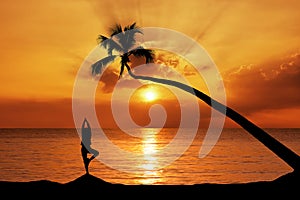 Yoga girl on the beach at sunrise