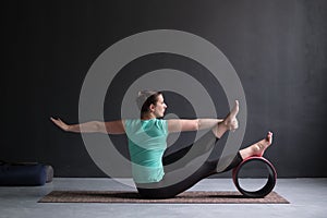 Yoga girl doing parivrtta navasana or twisted boat pose