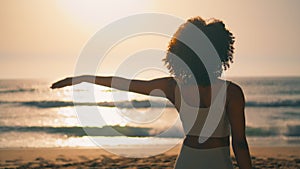 Yoga girl practicing gomukhasana on beach closeup. Woman stretching arms sunrise