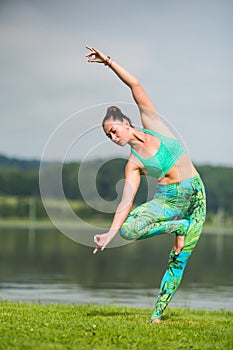 Yoga girl training outdoors on nature background.