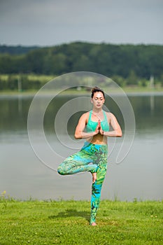 Yoga girl training outdoors on nature background.