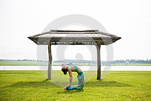 Yoga girl training outdoors on nature background.