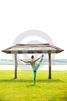 Yoga girl training outdoors on nature background.