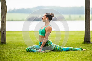 Yoga girl training outdoors on nature background.