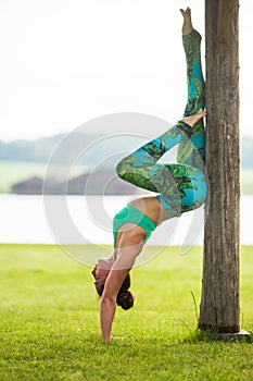 Yoga girl training outdoors on nature background.