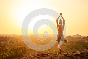 Yoga in Hampi temple copyspase at sunset.travel vacation copy spase lady with stylish jumpsuit