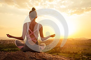 Yoga in Hampi temple copyspase at sunset.travel vacation copy spase lady with stylish jumpsuit