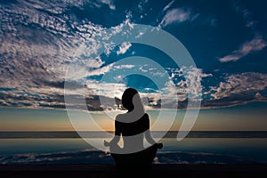 Yoga and healthy lifestyle background, abstract silhouette of woman meditating at the pool and sea.