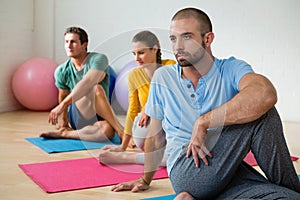 Yoga instructor guiding students in practicing Ardha Matsyendrasana