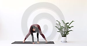 Yoga instructor performing Parivritta Ardha Prasarita Padottanasana exercise, intense stretching pose