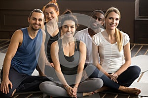 Yoga instructor posing with multiracial people at group training