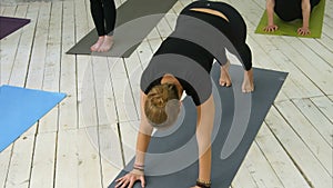 Yoga instructor showing asana to active young attenders