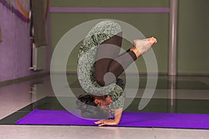 Yoga instructor working out by stretching in yoga in fitness class