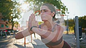 Yoga lady making asana training alone at city stadium closeup. Woman exercising