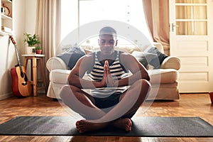 Yoga made me a better person. a young man practising yoga at home during the day.