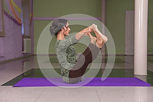 Yoga master demonstrating yoga asana in the gym