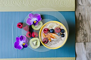 yoga mat with smoothie bowl and fruit for postworkout snack