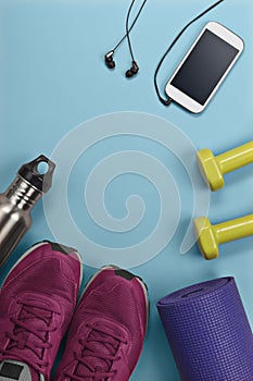 Yoga mat with sports shoes weights cellphone and water bottle