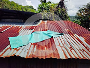 A yoga mat on top of rusty metal roof. Stock photo.