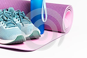 Yoga mat and water bottle isolated on white background.