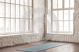 Yoga mat on wooden floor in empty room in yoga studio