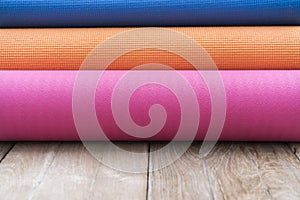 Yoga mats on the wooden table background