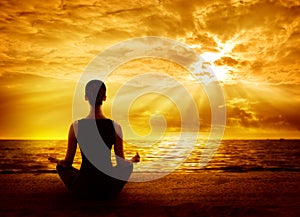 Yoga Meditating Sunrise, Woman Mindfulness Meditation on Beach photo