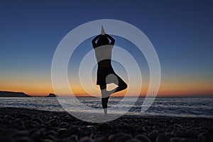 Yoga and meditation on calm beach at sunrise