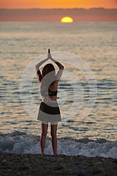 Yoga and meditation on calm beach at sunrise