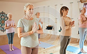 Yoga, meditation and fitness with a senior woman in an exercise class for holistic wellness or mental health. Gym, zen