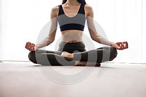 Yoga meditation at home. Relax concept with unrecognizable spiritual young woman sitting. Caucasian concentrating model. Copyspace