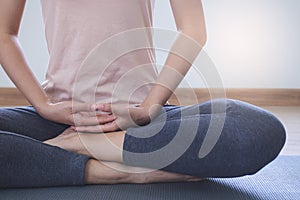 Yoga and meditation lifestyles. close up view of young beautiful woman practicing yoga namaste pose in the living room at home