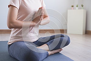 Yoga and meditation lifestyles. close up view of young beautiful woman practicing yoga namaste pose in the living room at home