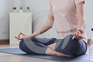 Yoga and meditation lifestyles. close up view of young beautiful woman practicing yoga namaste pose in the living room at home