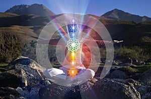 Yoga meditation outdoors. Glowing seven all chakra. Woman sits in a Upward Salute Lotus pose on mountain river view, Kundalini