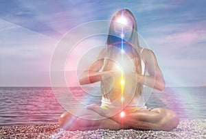 Yoga meditation outdoors. Glowing seven all chakra. Woman sits in a Upward Salute pose on beach sunset view, Kundalini energy.