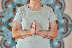 Yoga, meditation and praying senior hands or woman in creative zen studio for spiritual, wellness and healing zoom