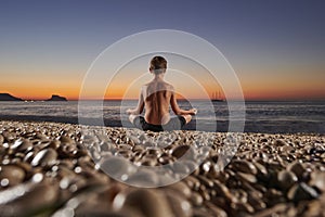 Yoga and meditation on the quiet beach at sunrise
