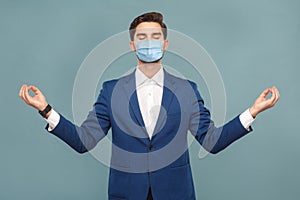 Yoga and meditation. young calm man with surgical medical mask standing and relaxing