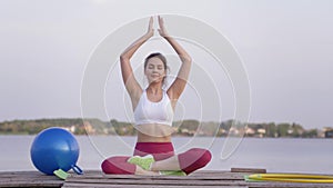 Yoga meditation, young happy yogi woman in lotus position doing yoga and pleasure spiritual calmnes on nature