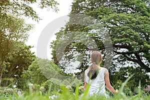 Yoga outdoors in public park. Asian woman sits in lotus position