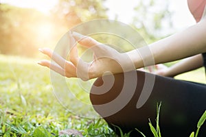 Yoga outdoors in summer park. young woman sits in lotus position