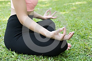 Yoga outdoors in summer park. young woman sits in lotus position
