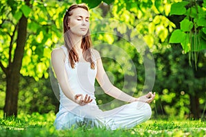 Yoga outdoors. Woman meditating in lotus position. Concept of he