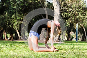 Yoga - outdoors young beautiful slender woman yoga instructor doing camel pose Ustrasana asana exercise outdoors.