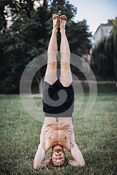 Yoga at park. Bearded man doing yoga in the green park. Concept of a healthy lifestyle