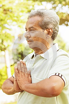 Yoga at park. Senior man in namaste pose - Elderly 60s people fitness, yoga and healthy lifestyle concept