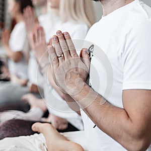 Yoga or Pilates training. Group of people relax and meditate and doing stretching exercises in fitness studio. Close-up